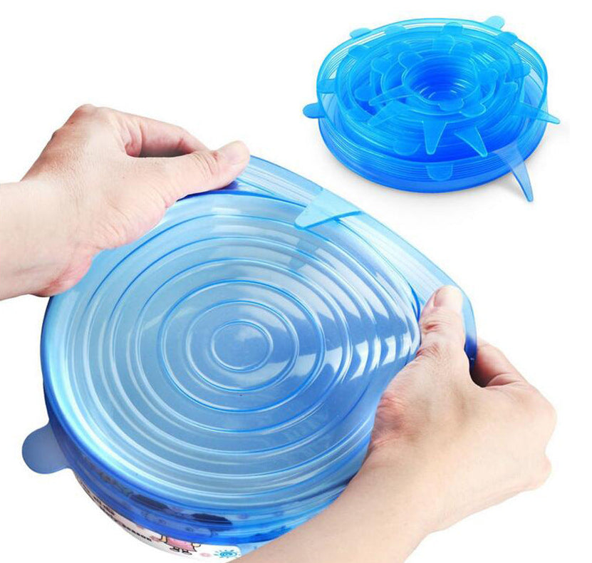 Blue silicone lid being stretched over a container by hands on a white background