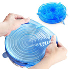 Blue silicone lid being stretched over a container by hands on a white background